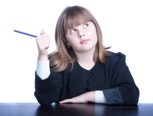 Nice Schoolgirl in black-and-white uniform sitting at a table — Stock Photo, Image