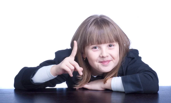 Nice Schoolgirl in black-and-white uniform sitting at a table — Stock Photo, Image