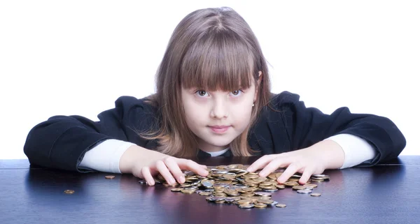 Beautiful girl in a school uniform sitting at a table and counts — Stock Photo, Image