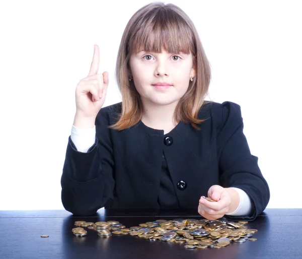 Menina bonita em um uniforme escolar sentado a uma mesa e conta — Fotografia de Stock