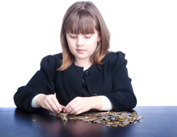 Vacker flicka i en skoluniform som sitter vid ett bord och räknas — Stockfoto