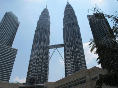 Kuala Lumpur - 25 Temmuz 2019: Turist olarak, şehir manzarasını alarak, Petronas İkiz Kuleleri 'ni aşağıdaki sokaktan ele geçirerek.
