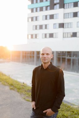 Günbatımında bir yönetici yüksek bir binanın arka planında duruyor.