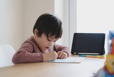 Ödevi için tablet kullanan çocuk izolasyonu, dijital tablet kullanan çocuk internetteki bilgileri ararken çoban köpeği 19 kilitleme, evde eğitim, sosyal uzaklık, E-öğrenme çevrimiçi eğitim