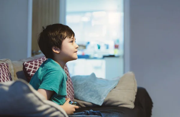 幸せな子供はビデオゲームやゲームコンソールを保持します 学校が休みの間に自宅でオンラインゲームを楽しんでいる子供は 少年はCovidのロックダウン中に家に滞在し 隔離と社会的距離や自己隔離 — ストック写真