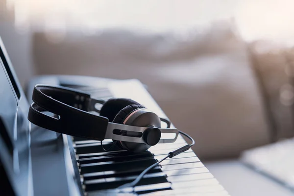 부드러운 디지털 피아노 키보드와 음악을 헤드폰 거실에서 휴식을 취하는 영화씬 — 스톡 사진