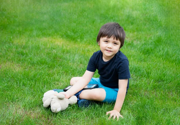 Dítě Sedí Trávě Pomocí Tabletu Pro Jeho Domácí Úkoly Zahradě — Stock fotografie
