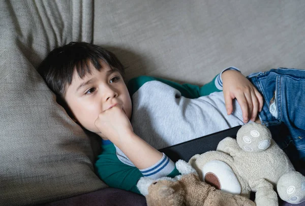 Candid Shot Kid Lying Sofa Biting His Finger Nails While — Stok Foto