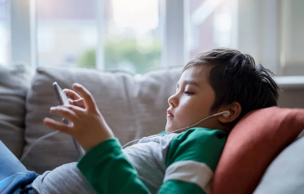 Happy Kid Wearing Earphones Listening Music Tablet Cute Boy Lying — Φωτογραφία Αρχείου