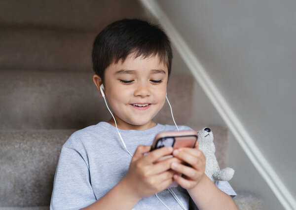 Candid Shot Child Sitting Staircase Wearing Earphones Listening Relaxing Music — Stock Photo, Image