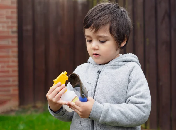 Aktivní Malý Chlapec Drží Sprej Láhev Zahradní Lopatka Zasazení Květin — Stock fotografie