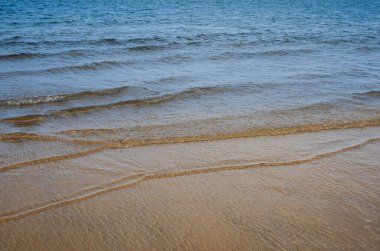 Kumsalda mavi okyanus dalgası, İngiliz sahilinde deniz kumsalı..