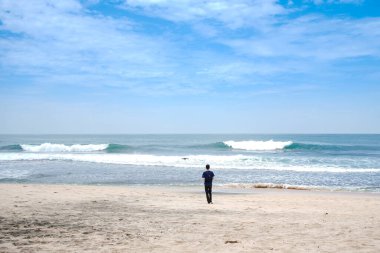 a tourist who is flying a drone on a white sandy beach for content needs.