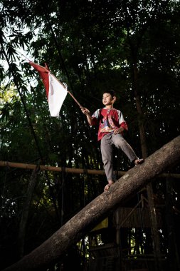 Bayrağı taşıyan Endonezya 'nın bağımsızlık baskısında oynayan ve heyecanlanan köy çocuklarının konsept fotoğrafı. : Bantul, Endonezya - 15 Ağustos 2021