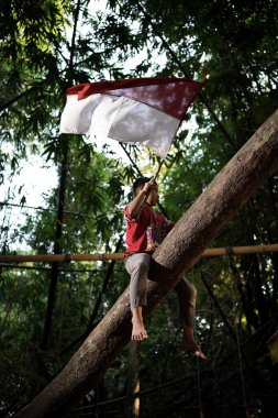 Bayrağı taşıyan Endonezya 'nın bağımsızlık baskısında oynayan ve heyecanlanan köy çocuklarının konsept fotoğrafı. : Bantul, Endonezya - 15 Ağustos 2021