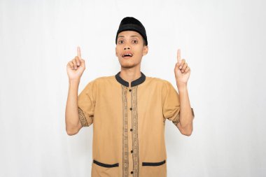 Geleneksel kıyafet giyen genç bir Asyalı iki eliyle gülümsüyor.