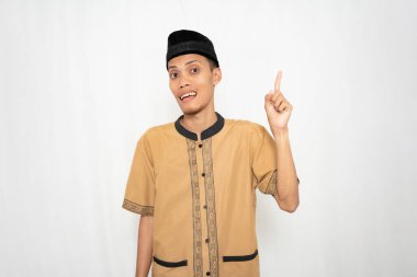 Geleneksel giysiler giyen genç bir adam yukarıya bakıyor.