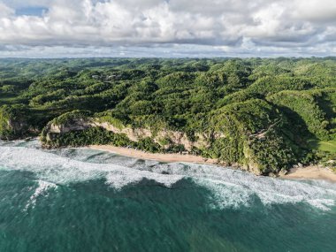 Yüksek açılı engebeli kıyı şeridi, yemyeşil uçurumlar ve kumlu plajlar.
