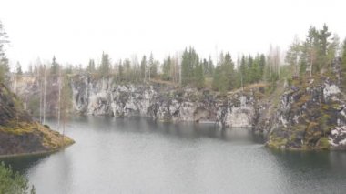 Sonbahar ormanlarının arasında sakin bir dağ gölü. Kuzey doğal manzara 4k video