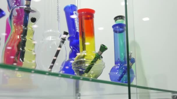 Colorful bongs for smoking cannabis, inside the shop showcase — Stock Video