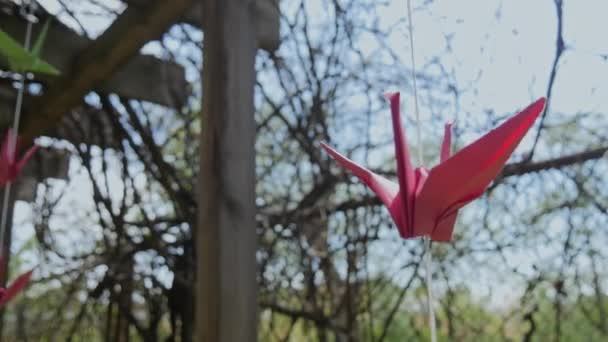 Origami guindaste de papel na corda suavemente balançar na brisa. Tema do festival oriental — Vídeo de Stock