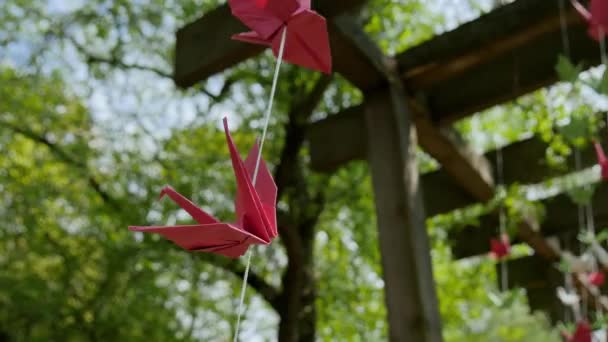 Grues en papier Origami japonais sur les cordes balancent doucement dans la brise — Video