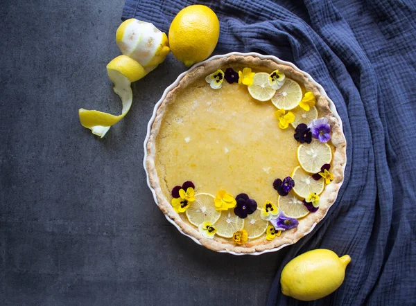 Creamy lemon pie with flower decorations. Top view photo of homemade dessert.