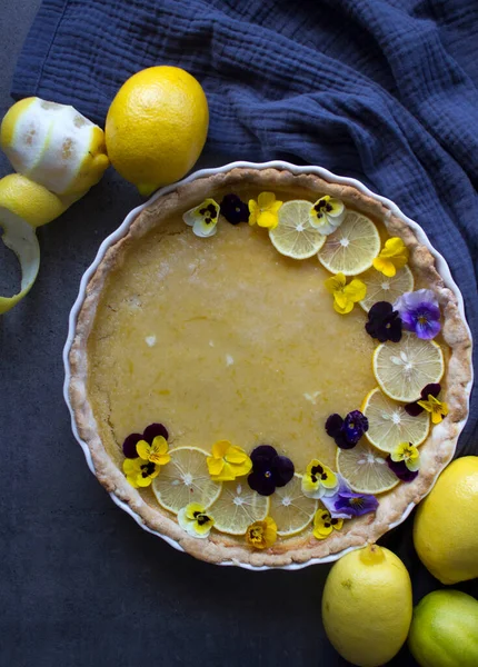 Creamy lemon pie with flower decorations. Top view photo of homemade dessert.