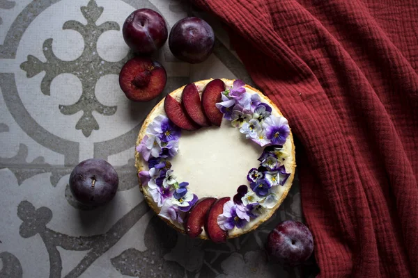 Gâteau Fromage Décoré Prunes Rouges Fleurs Comestibles Texture Tissu Fond — Photo