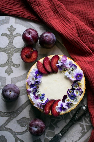 Gâteau Fromage Décoré Prunes Rouges Fleurs Comestibles Texture Tissu Fond — Photo