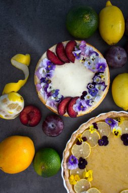 Masada peynirli kek ve limonlu turta. Yenilebilir çiçeklerle süslenmiş iki tatlı turtası.. 