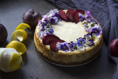 Mavi yabani nonoş çiçekleriyle süslenmiş ev yapımı cheesecake. Gri arkaplanda fotokopi alanı ile üstteki görüntü fotoğrafı.  