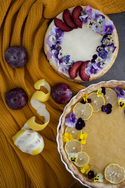 Cheesecake Lămâie Tartă Masă Două Plăcinte Desert Decorate Flori Comestibile — Fotografie, imagine de stoc
