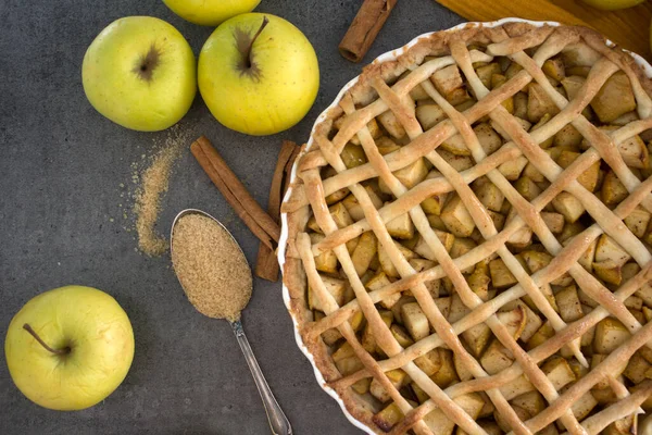 Delicious apple pie on a table. Fresh apples, cinnamon sticks and classic American pie top view photo. Thanksgiving menu ideas. Apple pie top view photo.  Homemade apple pie close up.