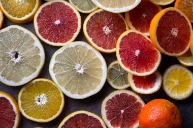 Meyveli sulu turunçgiller üst görüntü fotoğrafını dilimler. Taze portakallar, greyfurtlar, limonlar ve limonlardan yapılmış renkli bir arka plan. Sağlıklı yeme kavramı. 