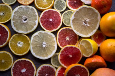 Meyveli sulu turunçgiller üst görüntü fotoğrafını dilimler. Taze portakallar, greyfurtlar, limonlar ve limonlardan yapılmış renkli bir arka plan. Sağlıklı yeme kavramı. 