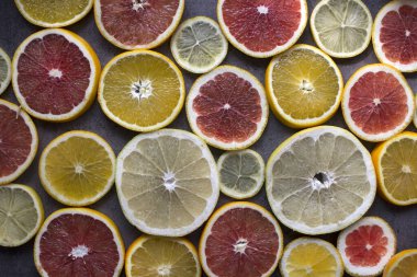 Meyveli sulu turunçgiller üst görüntü fotoğrafını dilimler. Taze portakallar, greyfurtlar, limonlar ve limonlardan yapılmış renkli bir arka plan. Sağlıklı yeme kavramı. 