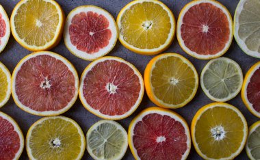 Meyveli sulu turunçgiller üst görüntü fotoğrafını dilimler. Taze portakallar, greyfurtlar, limonlar ve limonlardan yapılmış renkli bir arka plan. Sağlıklı yeme kavramı. 