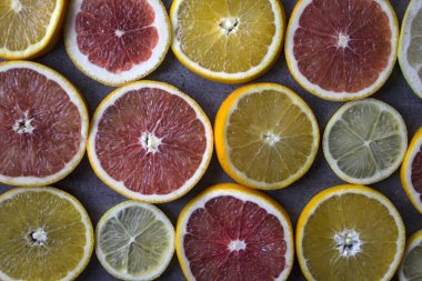 Meyveli sulu turunçgiller üst görüntü fotoğrafını dilimler. Taze portakallar, greyfurtlar, limonlar ve limonlardan yapılmış renkli bir arka plan. Sağlıklı yeme kavramı. 