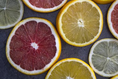 Meyveli sulu turunçgiller üst görüntü fotoğrafını dilimler. Taze portakallar, greyfurtlar, limonlar ve limonlardan yapılmış renkli bir arka plan. Sağlıklı yeme kavramı. 