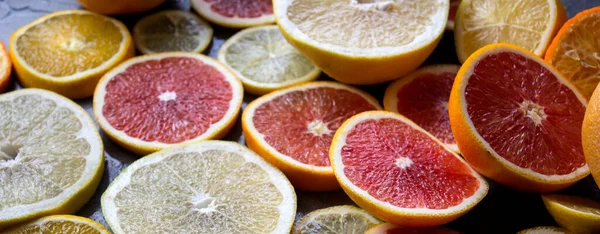 Juicy citrus fruits slices top view photo. Colorful background made of fresh oranges, grapefruits, limes and lemons. Healthy eating concept.