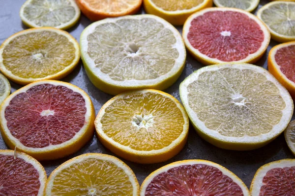 Juicy citrus fruits slices top view photo. Colorful background made of fresh oranges, grapefruits, limes and lemons. Healthy eating concept.