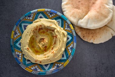 Humus tabakasının en üstteki görüntüsü. Orta Doğu yemekleri. Sağlıklı beslenme konsepti. Kopyalama alanı olan gri arkaplan.