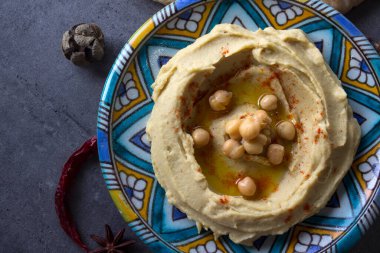 Renkli seramik tabakta taze ev yapımı humus fotoğrafı. Dengeli yemek fotoğrafı. Sağlıklı beslenme konsepti. Orta Doğu 'nun otantik yemekleri. 