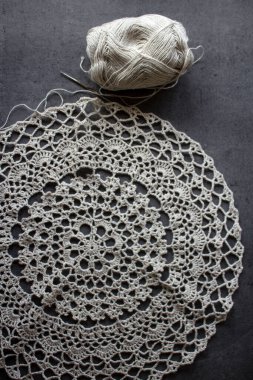 Güzel örgü desenli yakın plan fotoğraf. Organik iplikten yapılmış kırsal stil masa örtüsü. Gri arka plan. Sıcak tığ işi. Gri desenli arka planda güzel keten masa örtüsünün en üstteki fotoğrafı. Hobiler ve el sanatları konsepti.