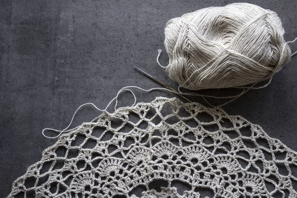 Crochet table mat close up photo. Hand made linen table cloth on grey background with copy space. Eco friendly decor elements.