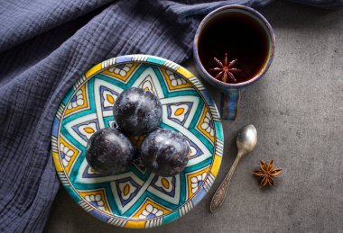 Güzel otantik tabakta taze erikler, bir fincan anason çayı ve küçük gümüş kaşık manzaralı fotoğraf. Yine de hayat yemeği. Orta Doğu 'nun geleneksel süsü.