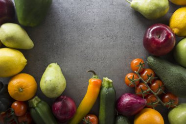 Taze organik meyve ve sebzelerden yapılmış sınır veya çerçeve. Koyu gri arkaplan ve fotokopi alanı. Sağlıklı beslenme konsepti. Vejetaryen yemek malzemeleri üst görünüm fotoğrafı.. 
