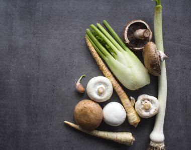 Şampiyonlar, pırasa, yaban havucu, sarımsak ve rezene gri arka planda. Taze mevsimlik sebzelerin en iyi görüntüsü. Sağlıklı menü fikirleri.
