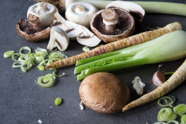 Şampiyonlar, pırasa, yaban havucu, sarımsak ve rezene gri arka planda. Taze mevsimlik sebzelerin en iyi görüntüsü. Sağlıklı menü fikirleri.